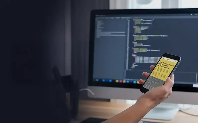 Top view of someone holding an phone next to laptop